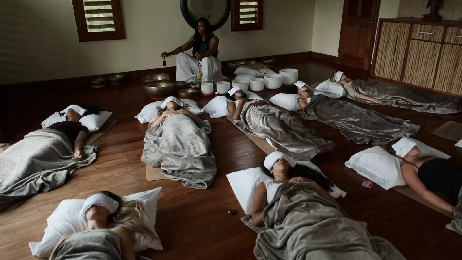 Guests resting under blankets during a sound bath in Jamaica